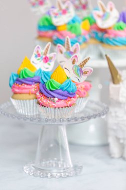 Tek boynuzlu at kek kek standları üzerine çok renkli buttercream krema ile.