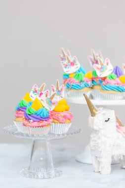 Tek boynuzlu at kek kek standları üzerine çok renkli buttercream krema ile.