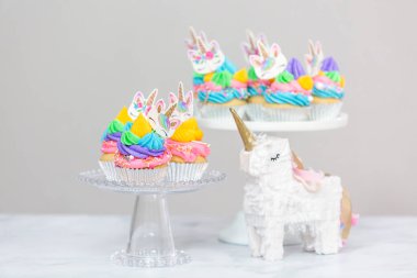 Tek boynuzlu at kek kek standları üzerine çok renkli buttercream krema ile.