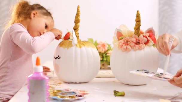 Маленькая Девочка Мать Рисуют Лицо Единорогов Своей Ремесленной Тыкве Хэллоуин — стоковое видео