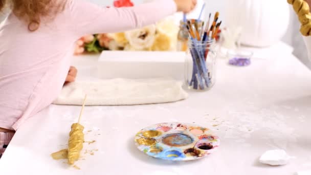 母と娘のゴールドでペイント ペイント粘土彫刻ホルンとハロウィーンのユニコーンをテーマにしたクラフト カボチャを飾るための耳 — ストック動画