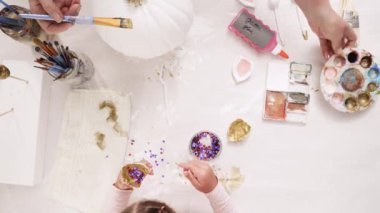 Anne ve kızı ile altın boyama boya Kil heykel boynuz ve zanaat kabaklar unicorn tema ile Cadılar Bayramı için dekorasyon için kulaklar.