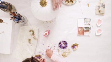 Anne ve kızı ile altın boyama boya Kil heykel boynuz ve zanaat kabaklar unicorn tema ile Cadılar Bayramı için dekorasyon için kulaklar.