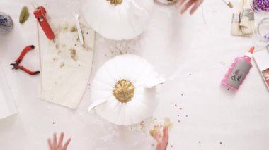 Üstten görünüm. Anne ve kızı zanaat kabak çiçekleri ile dekorasyon tema kabak Cadılar Bayramı için bir tek boynuzlu at yapmak