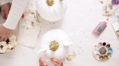 Üstten görünüm. Anne ve kızı zanaat kabak çiçekleri ile dekorasyon tema kabak Cadılar Bayramı için bir tek boynuzlu at yapmak