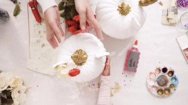 Üstten görünüm. Anne ve kızı zanaat kabak çiçekleri ile dekorasyon tema kabak Cadılar Bayramı için bir tek boynuzlu at yapmak