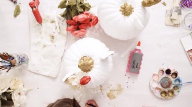 Küçük kız ve annesi boyama yüzü onun zanaat Cadılar Bayramı için kabak üzerinde bir tek boynuzlu at