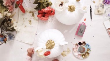 Üstten görünüm. Anne ve kızı yüzü bir tek boynuzlu at boyama ve zanaat kabak çiçekleri ile dekorasyon tema kabak Cadılar Bayramı için bir tek boynuzlu at yapmak