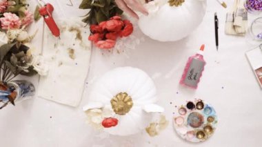 Üstten görünüm. Anne ve kızı yüzü bir tek boynuzlu at boyama ve zanaat kabak çiçekleri ile dekorasyon tema kabak Cadılar Bayramı için bir tek boynuzlu at yapmak