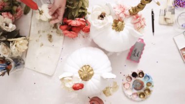 Üstten görünüm. Anne ve kızı yüzü bir tek boynuzlu at boyama ve zanaat kabak çiçekleri ile dekorasyon tema kabak Cadılar Bayramı için bir tek boynuzlu at yapmak