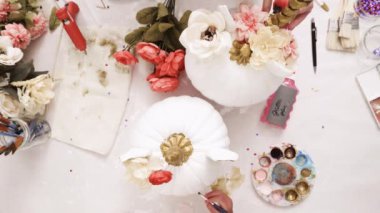 Üstten görünüm. Anne ve kızı yüzü bir tek boynuzlu at boyama ve zanaat kabak çiçekleri ile dekorasyon tema kabak Cadılar Bayramı için bir tek boynuzlu at yapmak