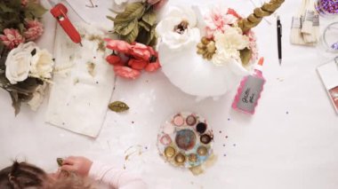 Üstten görünüm. Anne ve kızı yüzü bir tek boynuzlu at boyama ve zanaat kabak çiçekleri ile dekorasyon tema kabak Cadılar Bayramı için bir tek boynuzlu at yapmak