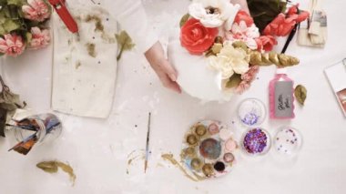 Üstten görünüm. Anne ve kızı yüzü bir tek boynuzlu at boyama ve zanaat kabak çiçekleri ile dekorasyon tema kabak Cadılar Bayramı için bir tek boynuzlu at yapmak