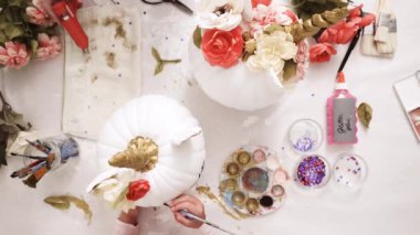 Üstten görünüm. Anne ve kızı yüzü bir tek boynuzlu at boyama ve zanaat kabak çiçekleri ile dekorasyon tema kabak Cadılar Bayramı için bir tek boynuzlu at yapmak