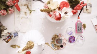 Üstten görünüm. Anne ve kızı yüzü bir tek boynuzlu at boyama ve zanaat kabak çiçekleri ile dekorasyon tema kabak Cadılar Bayramı için bir tek boynuzlu at yapmak