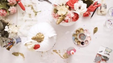 Üstten görünüm. Anne ve kızı yüzü bir tek boynuzlu at boyama ve zanaat kabak çiçekleri ile dekorasyon tema kabak Cadılar Bayramı için bir tek boynuzlu at yapmak