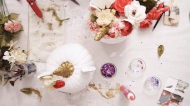 Üstten görünüm. Anne ve kızı yüzü bir tek boynuzlu at boyama ve zanaat kabak çiçekleri ile dekorasyon tema kabak Cadılar Bayramı için bir tek boynuzlu at yapmak