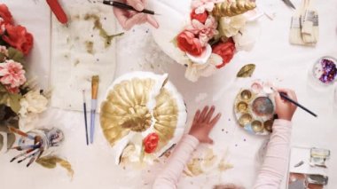 Üstten görünüm. Anne ve kızı yüzü bir tek boynuzlu at boyama ve zanaat kabak çiçekleri ile dekorasyon tema kabak Cadılar Bayramı için bir tek boynuzlu at yapmak