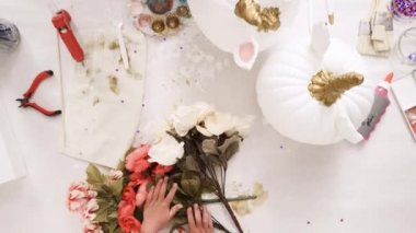 Zaman atlamalı. Üstten görünüm. Anne ve kızı yüzü bir tek boynuzlu at boyama ve zanaat kabak çiçekleri ile dekorasyon tema kabak Cadılar Bayramı için bir tek boynuzlu at yapmak