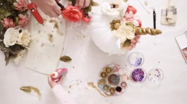 Zaman atlamalı. Üstten görünüm. Anne ve kızı yüzü bir tek boynuzlu at boyama ve zanaat kabak çiçekleri ile dekorasyon tema kabak Cadılar Bayramı için bir tek boynuzlu at yapmak