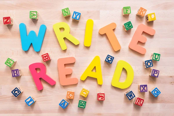 Bright color wooden WRITE and READ signs on wood desk.