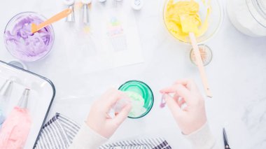 Adım adım. Boru Çantalar renkli buttercream frosting unicorn Tema vanilyalı kek süslemeleri için hazırlanıyor.