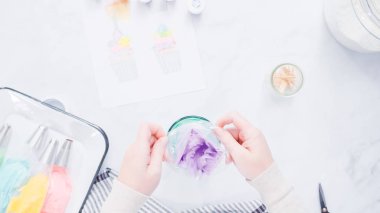 Adım adım. Boru Çantalar renkli buttercream frosting unicorn Tema vanilyalı kek süslemeleri için hazırlanıyor.