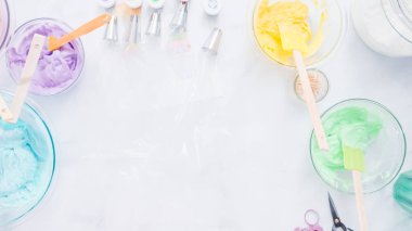 Adım adım. Boru Çantalar renkli buttercream frosting unicorn Tema vanilyalı kek süslemeleri için hazırlanıyor.