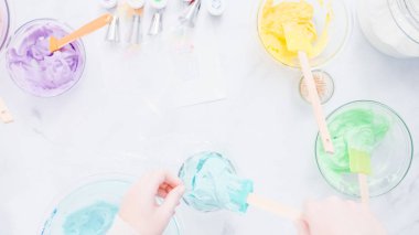 Adım adım. Boru Çantalar renkli buttercream frosting unicorn Tema vanilyalı kek süslemeleri için hazırlanıyor.