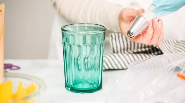 Adım adım. Boru Çantalar renkli buttercream frosting unicorn Tema vanilyalı kek süslemeleri için hazırlanıyor.