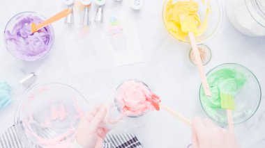 Adım adım. Boru Çantalar renkli buttercream frosting unicorn Tema vanilyalı kek süslemeleri için hazırlanıyor.