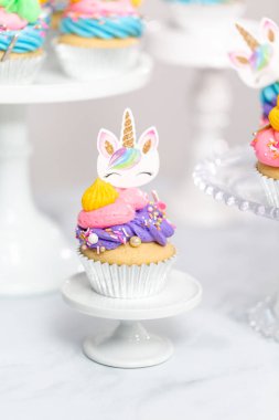 Tek boynuzlu at kek kek standları üzerine çok renkli buttercream krema ile.