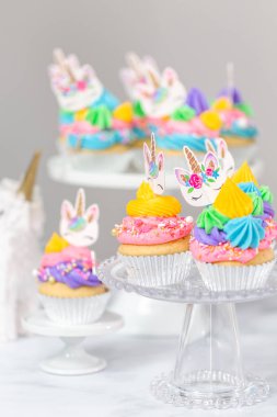 Tek boynuzlu at kek kek standları üzerine çok renkli buttercream krema ile.