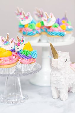 Tek boynuzlu at kek kek standları üzerine çok renkli buttercream krema ile.
