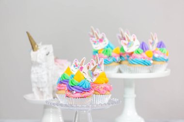 Tek boynuzlu at kek kek standları üzerine çok renkli buttercream krema ile.