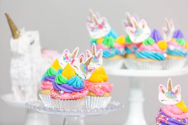 Tek boynuzlu at kek kek standları üzerine çok renkli buttercream krema ile.