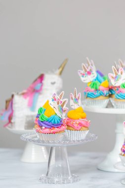 Tek boynuzlu at kek kek standları üzerine çok renkli buttercream krema ile.