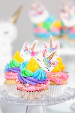 Tek boynuzlu at kek kek standları üzerine çok renkli buttercream krema ile.