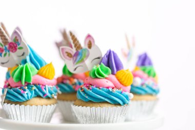 Tek boynuzlu at kek kek standları üzerine çok renkli buttercream krema ile.