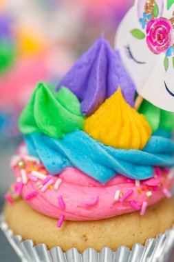 Metal tepsi üzerine çok renkli buttercream krema ile tek boynuzlu at cupcakes.