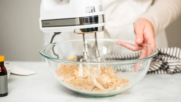 Working With A Handheld Electric Mixer In The Kitchen Stock Photo