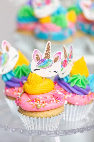 Tek boynuzlu at kek kek standları üzerine çok renkli buttercream krema ile.