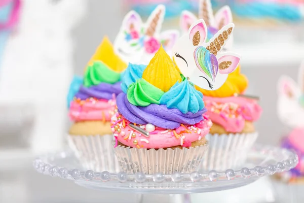 Tek boynuzlu at kek kek standları üzerine çok renkli buttercream krema ile.