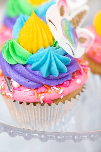 Tek boynuzlu at kek kek standları üzerine çok renkli buttercream krema ile.