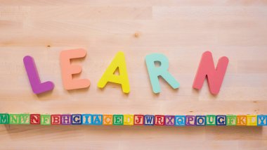 Kelime öğrenmek çok renkli ahşap mektup ahşap masa üstünde üzerinden.