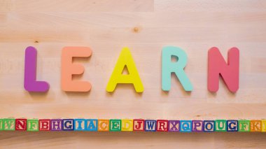 Kelime öğrenmek çok renkli ahşap mektup ahşap masa üstünde üzerinden.
