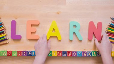 Kelime öğrenmek çok renkli ahşap mektup ahşap masa üstünde üzerinden.