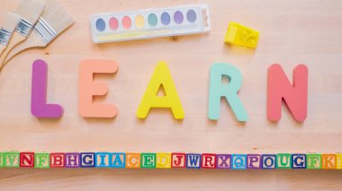 Kelime öğrenmek çok renkli ahşap mektup ahşap masa üstünde üzerinden.