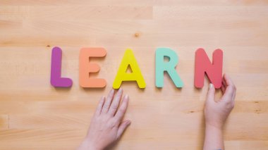 Kelime öğrenmek çok renkli ahşap mektup ahşap masa üstünde üzerinden.