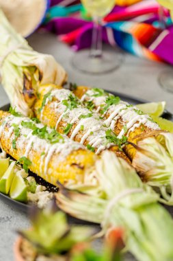 Baharat ve bir servis tabağı üzerinde taze kişniş ile süslenmiş Meksika Caddesi Mısır elote ızgara.